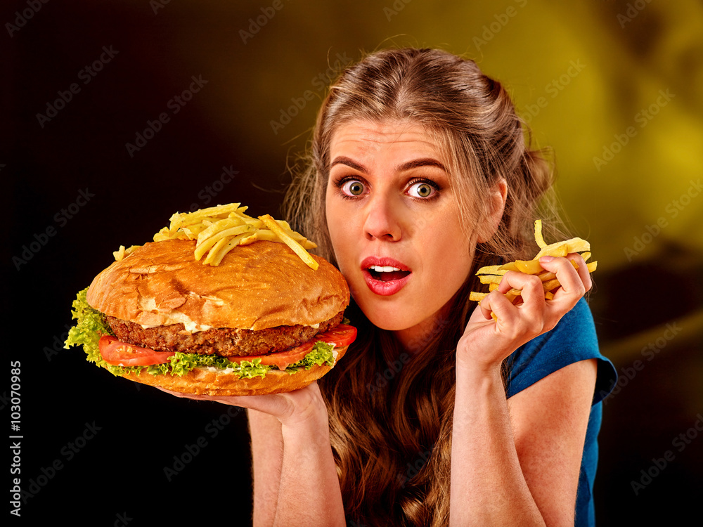 Girl keeps big hamburger. Fastfood concept. Cheeseburger on foreground ...