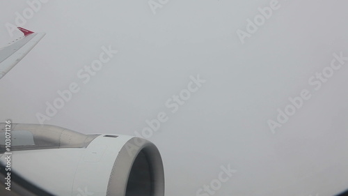 View of the engine of the aircraft flying in a dense clouds photo