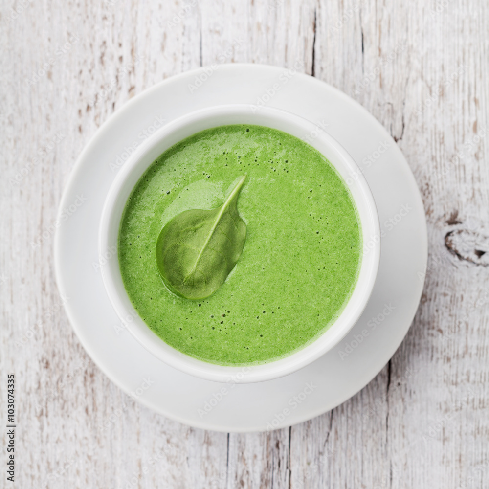 Spinach cream soup in bowl on white rustic table, top view Spinach cream soup in bowl on white rustic table, top view