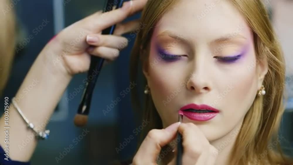 Beautiful young woman apply lipstick on her lips Beautiful young woman apply lipstick on her lips