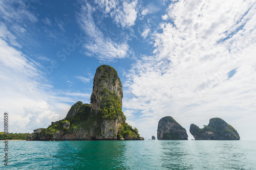 Thailand tropical island cliffs over ocean water during tourist boat trip in Railay Beach resort