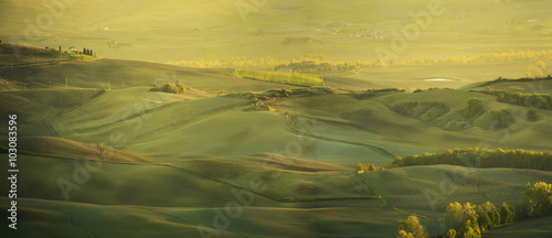 Wavy fields in Tuscany at sunset, Italy. Natural outdoor seasonal spring background. Panoramic view.