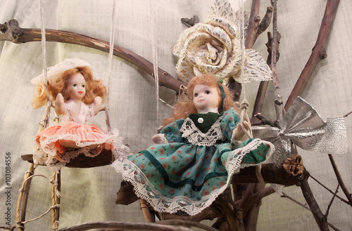 Obraz na plátně Porcelain dolls on swings photo