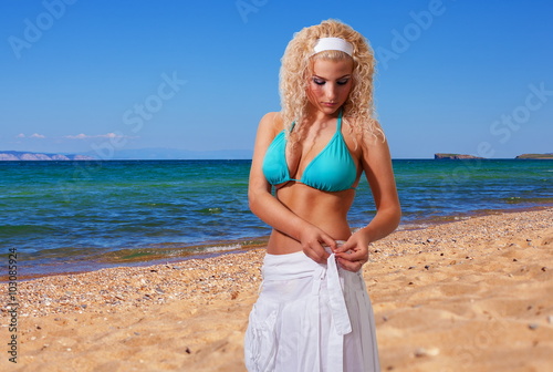 Girl in a blue bikini on the beach.
