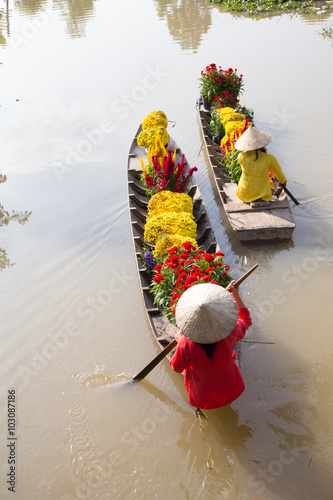 Vietnamese Woman with conical hat on a flower boat in SaDec
