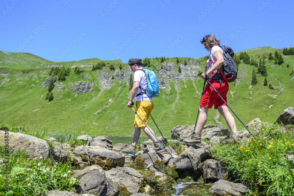 Wanderer überschreiten kleinen Bach im Gebirge