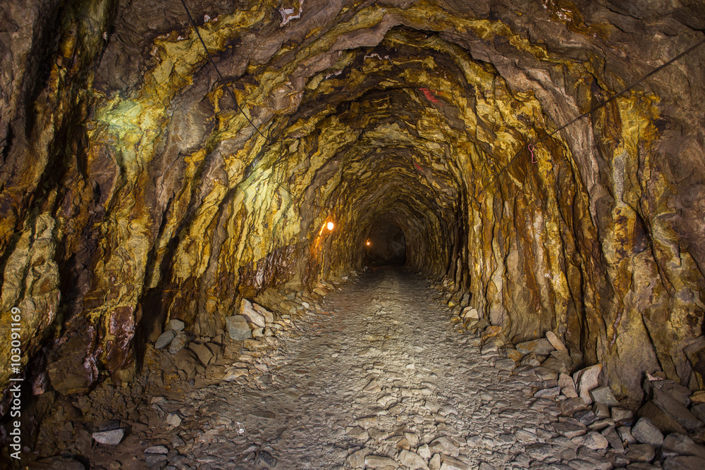Obraz premium Old abandoned gold mine tunnel passage with yellow sulfur dirt