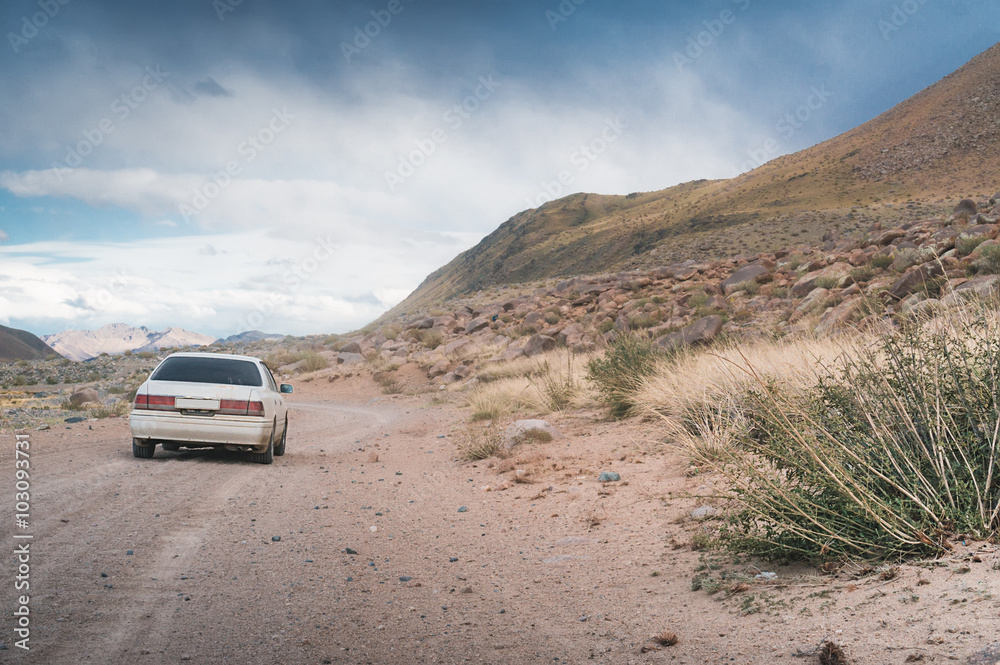 The car moves on a gravel road The car moves on a gravel road