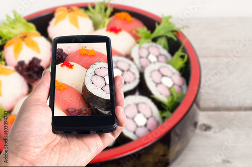 Modern mobile phone used to take pictures of nicely decorated sushi