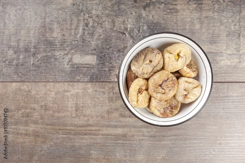 Obraz Wysuszone figi w pucharze na drewnianym tle