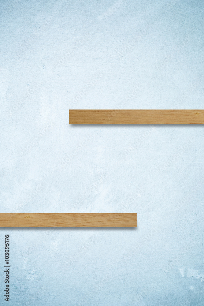 Empty wooden shelves on blue cement wall background Empty wooden shelves on blue cement wall background