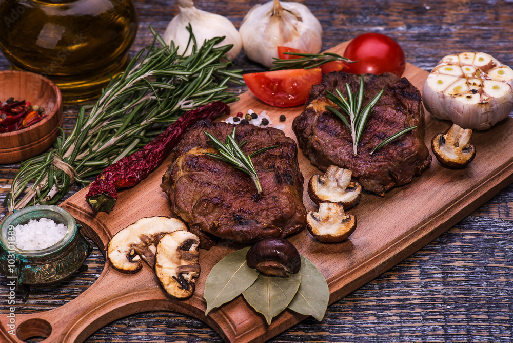 Beef Steak, salt, pepper, garlic, rosemary on the black board, background. Beef Steak, salt, pepper, garlic, rosemary on the black board, background.