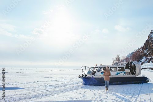Εκτύπωση καμβά girl walking on the frozen Lake Baikal in the side of the boat hovercraft