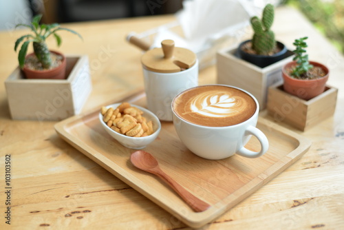 hot latte art with cactus in coffee shop on table wooden