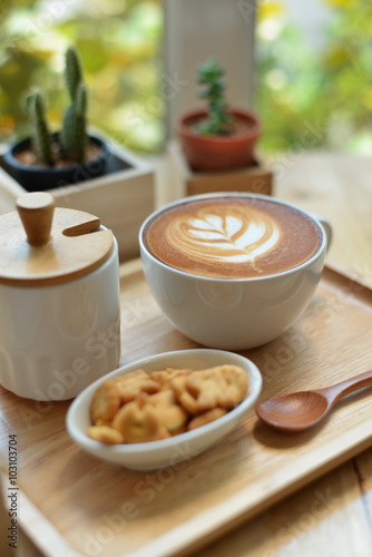 hot latte art  with cactus in coffee shop on table wooden
