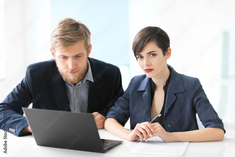 Business people discussing ideas at meeting using laptop Business people discussing ideas at meeting using laptop