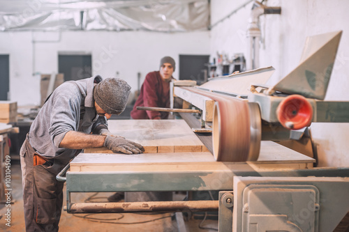 Carpenter using belt sander / Carpenter sanding a wood with belt sander