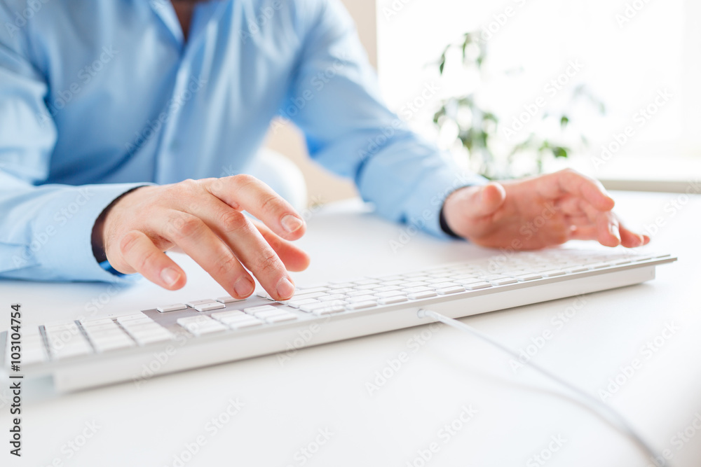 Fototapeta premium Man office worker typing on the keyboard