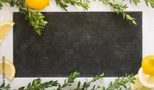 Lemons and branches of buxus on the background of black chalkboard
