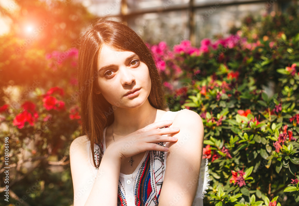 Young pretty girl posing near beautiful leaves and flowers Young pretty girl posing near beautiful leaves and flowers
