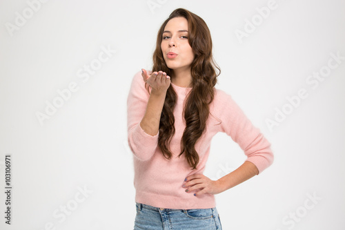 Lovely charming young woman in pink sweatshirt sending a kiss photo