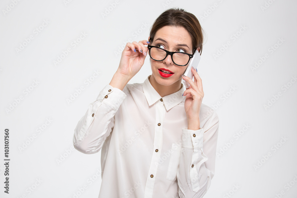 Thoughtful lovely businesswoman in glasses talking on cell phone Thoughtful lovely businesswoman in glasses talking on cell phone