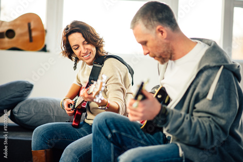 Musician teaching his girlfriend playing electric guitar