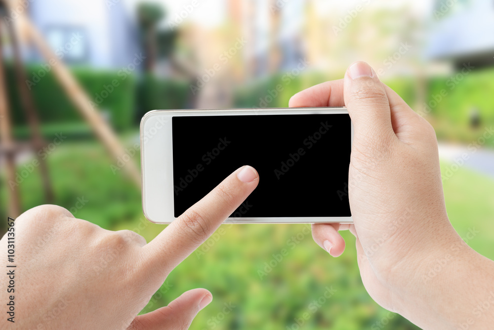 Concept of Woman hand touching smartphone in garden Concept of Woman hand touching smartphone in garden
