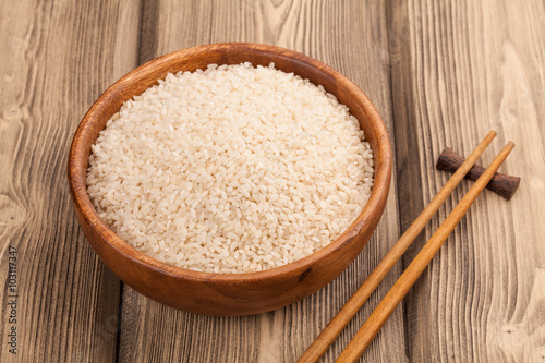 A wooden bowl of grain white rice chopstick