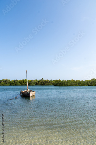 An old wooden boat floating on a river in Tanzania, Africa photo