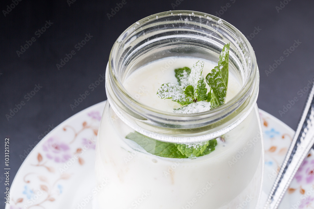 Open glass jar of yogurt