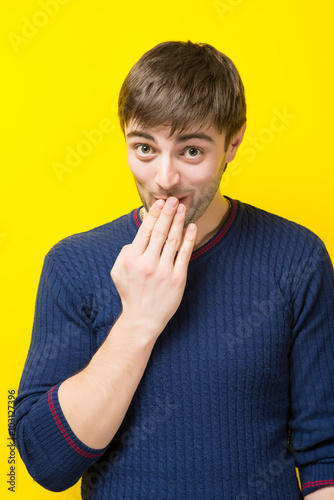 Young man yawns and covered his mouth with hand