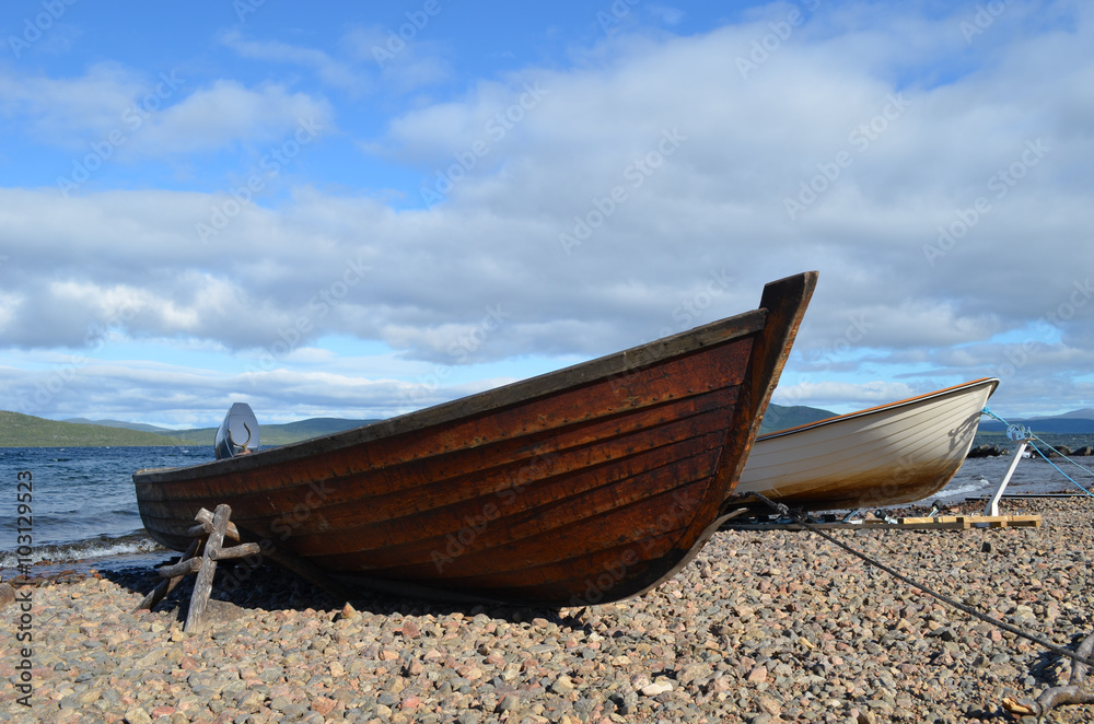 Wooden boats on the gravel shore of lake Torneträsk, subarctic Swedish Lapland