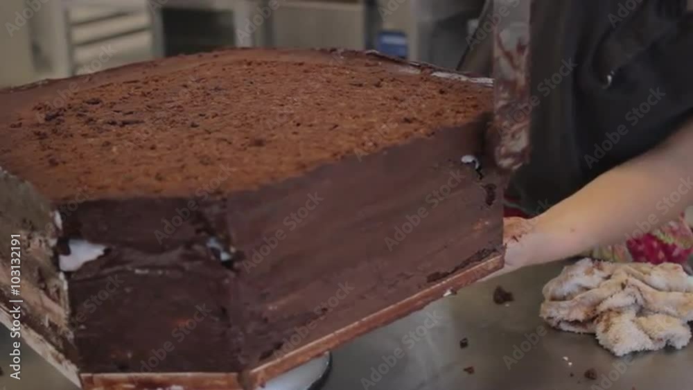 Close up of chocolate frosting being smoothed on a triple layer wedding cake Close up of chocolate frosting being smoothed on a triple layer wedding cake