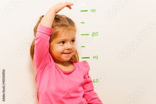 Obraz na plátně Height measurement by little girl at the wall