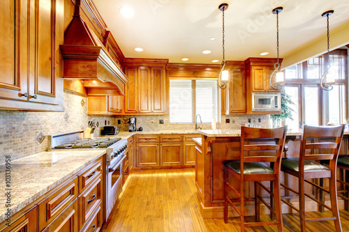 Brilliant kitchen with stained wood cabinets and hardwood floor.