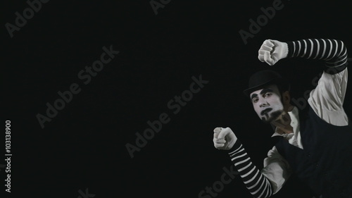 Young funny mime performing a invisible wall act