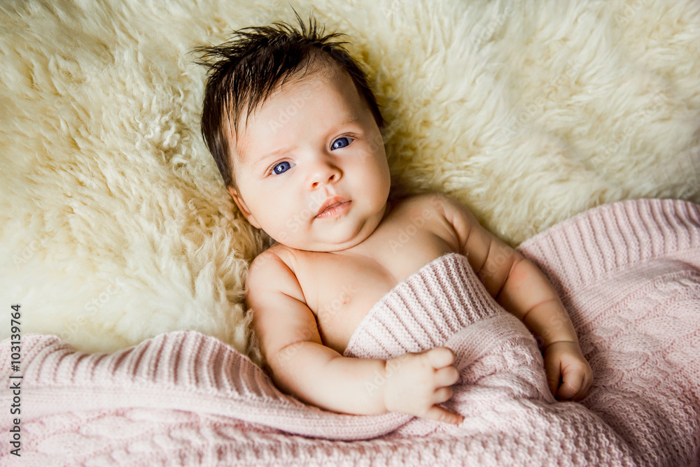 newborn baby lying with open eyes in crib