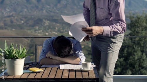 Young businesswoman getting rebuke from her boss on terrace in the country
