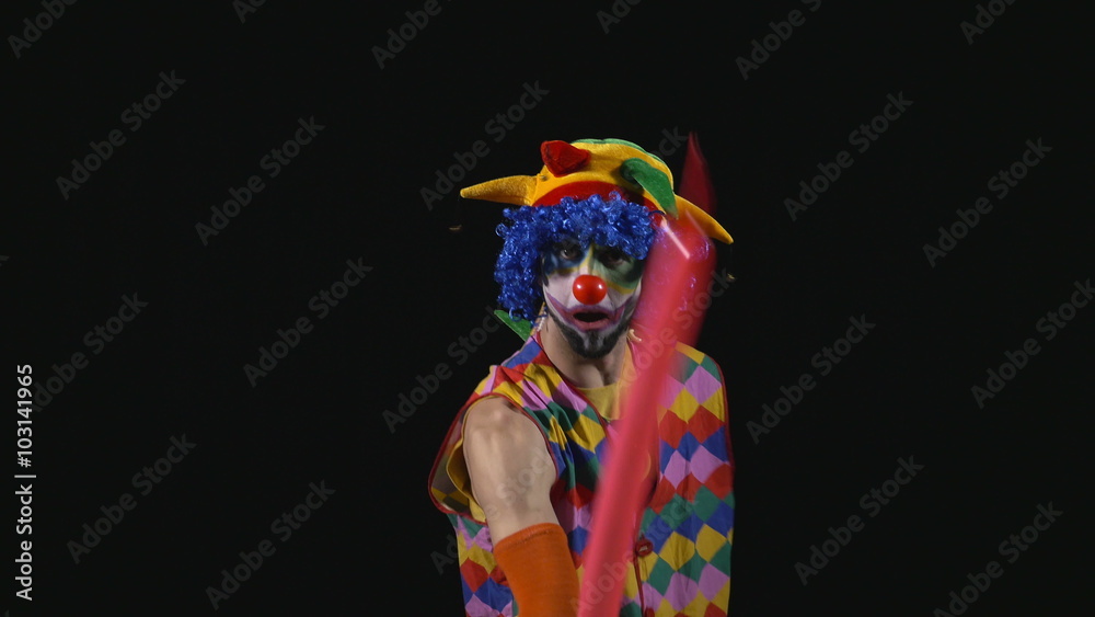 Young funny clown making a dog from a balloon and bursting it with a needle Young funny clown making a dog from a balloon and bursting it with a needle