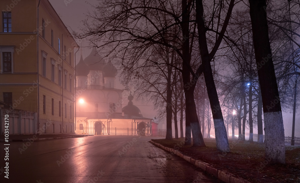 Ancient stone church in the center of the city at night in the fog. Yaroslavl, Russia