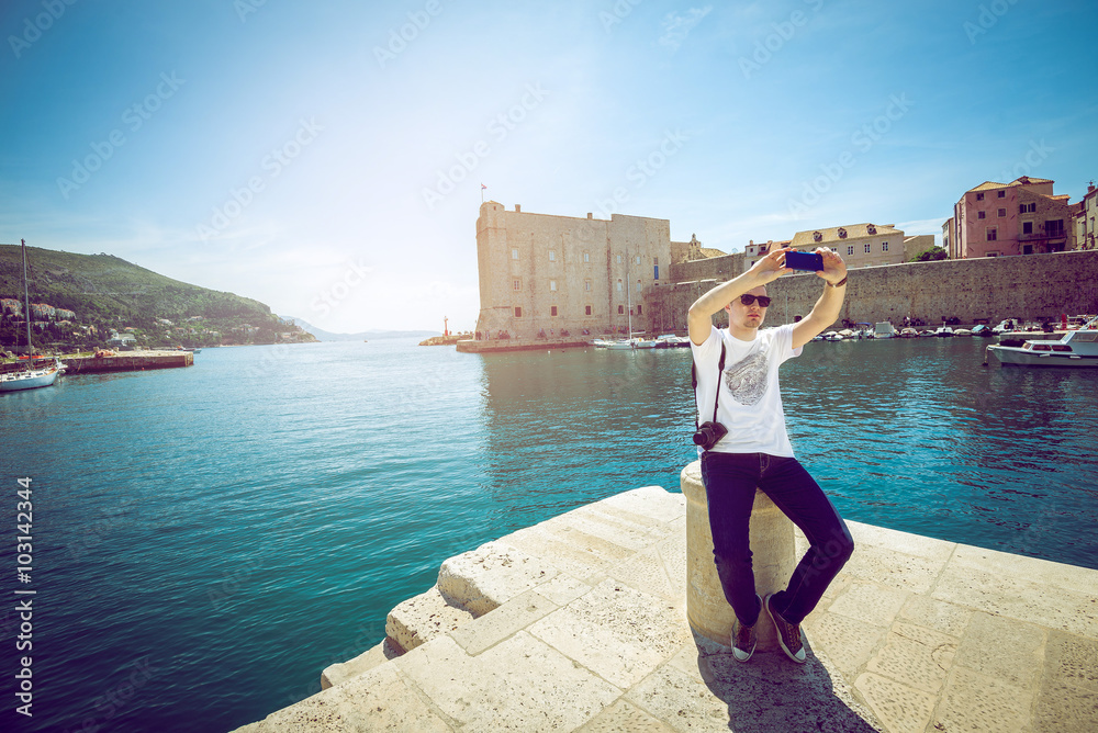 Young man taking selfie at Dubrovnik harbor