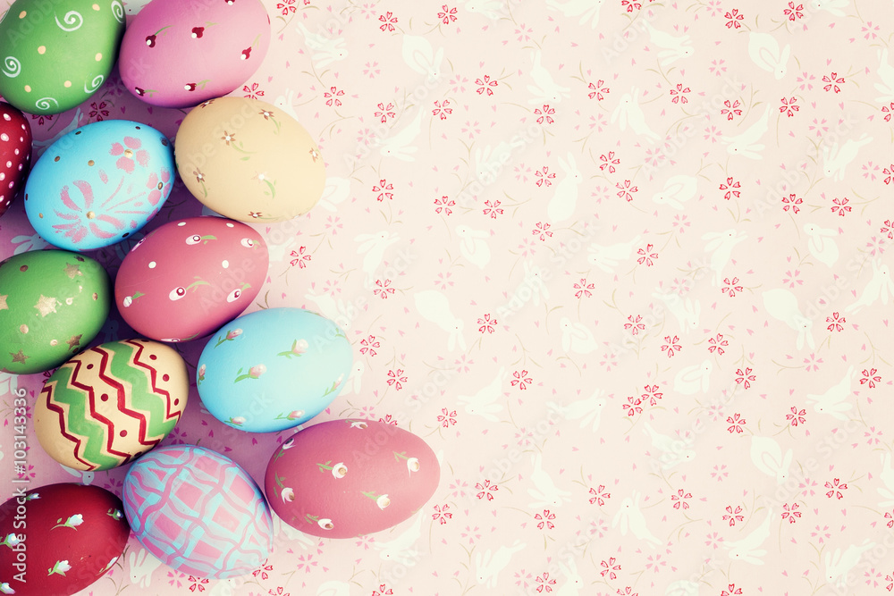 Vintage pastel easter eggs over flower patterned background