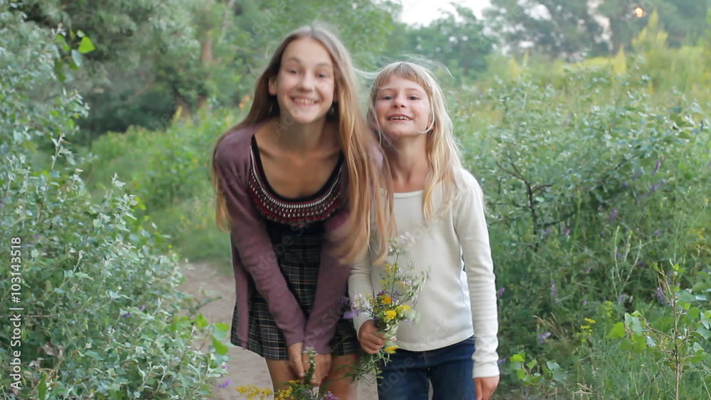 Two girls running fun and laughing, happy children in summer nature