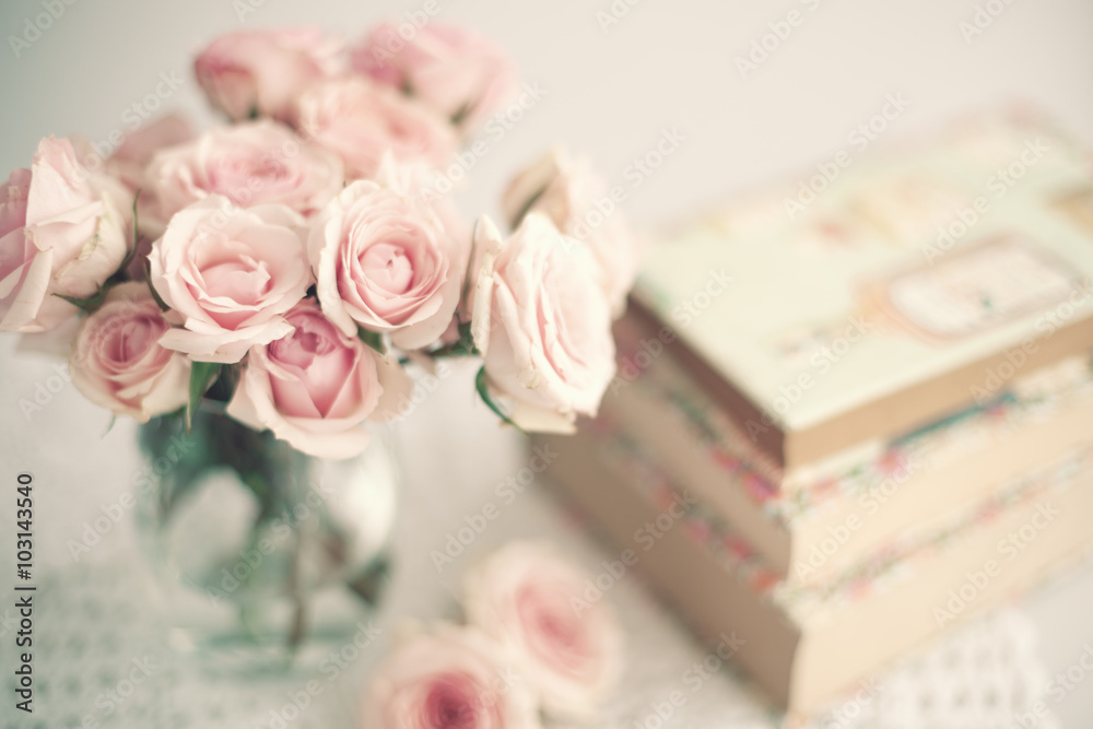 Fototapeta premium Róże w kryształowym wazonie i książki z rocznymi kurtkami przeciwpyłowymi