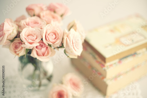 Roses in a crystal vase and books with vintage dust jackets
