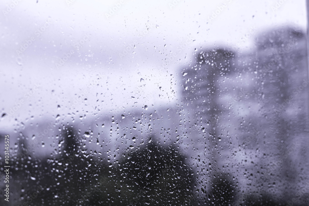 Rain drops on the window in the big city. Big building on the background. Rain drops on the window in the big city. Big building on the background.