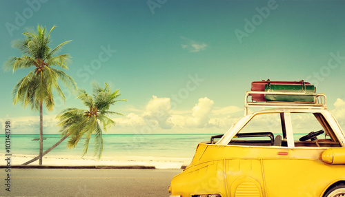 Travel destination: vintage classic car parked near the beach with bags on a roof - Honeymoon trip in summer