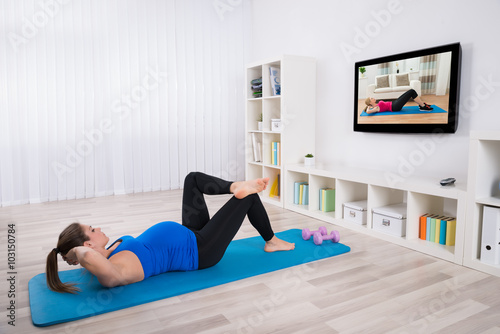 Pregnant Female Doing Workout By Lying On Exercise Mat