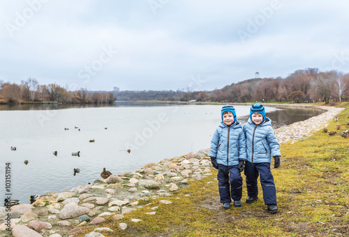Five-year-old twins, in the fall, near ducks on the street near the the Moscow river